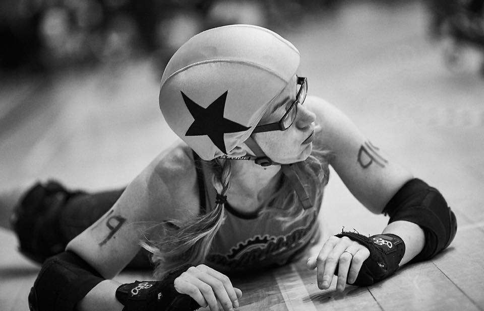 Black and white photo of a skater lying on the floor.